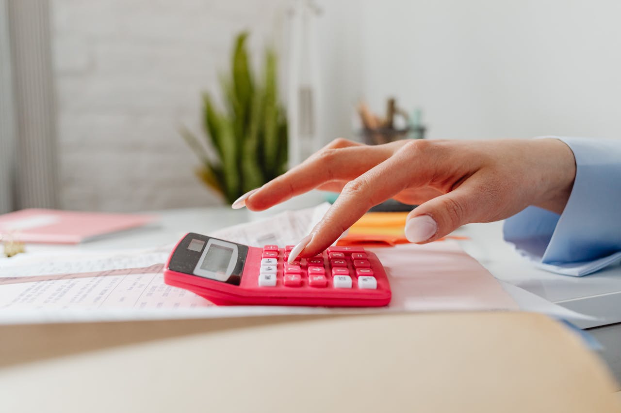 Close-Up Shot of a Person using Pink Calculator